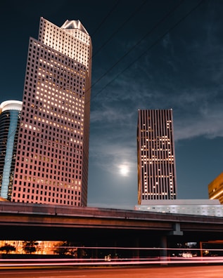 brown high rise building under dark clouds