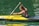 man in black shorts riding yellow kayak on green water during daytime