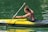 man in black shorts riding yellow kayak on green water during daytime