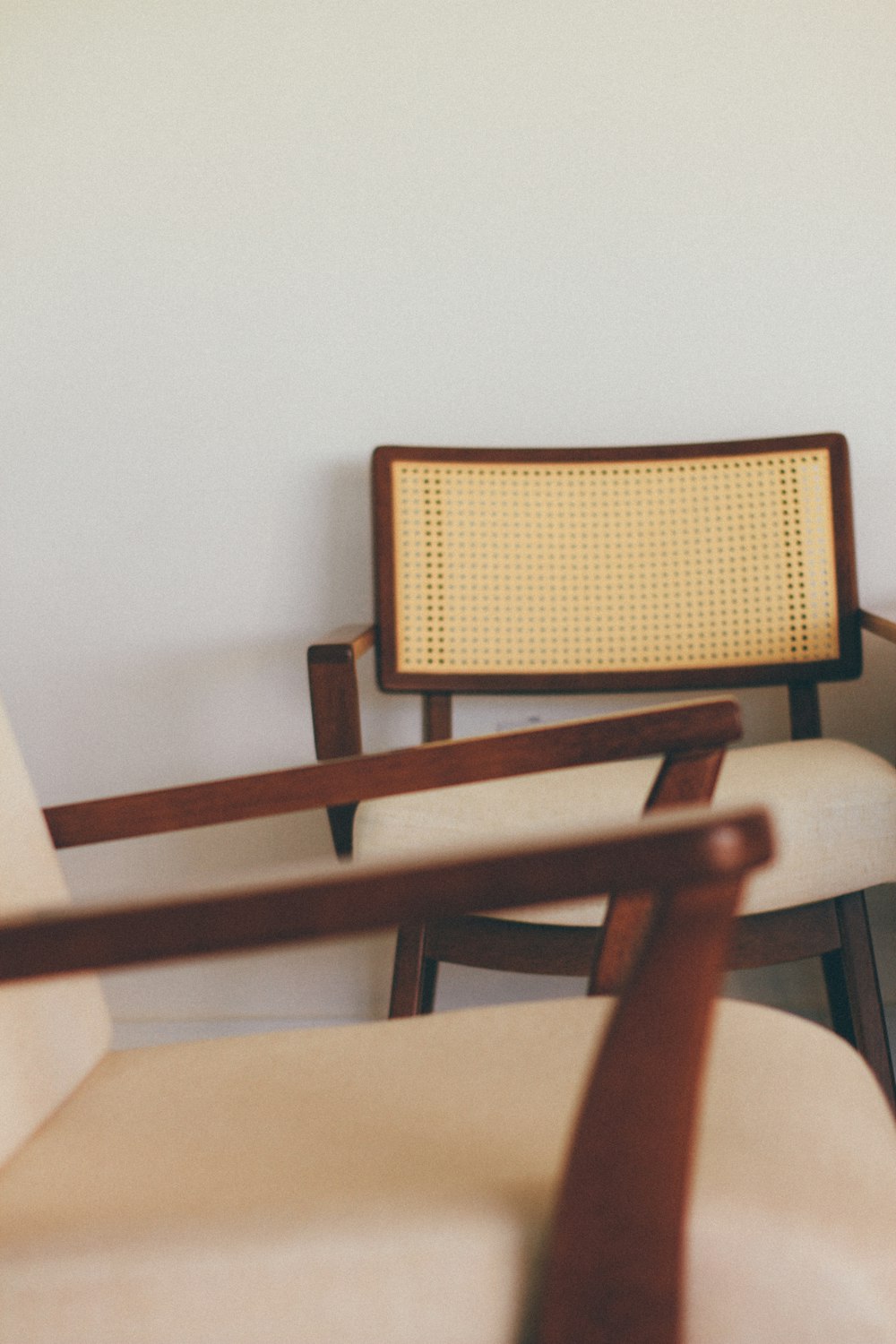 chaise en bois marron à côté d’un mur blanc