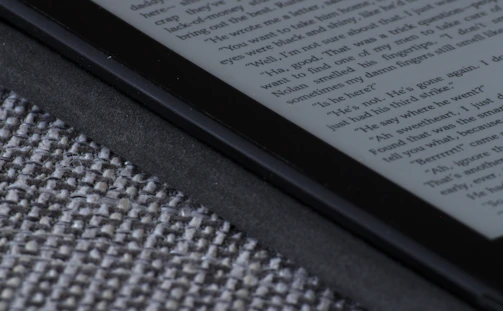 Close-up of a user interacting with an intuitive ebook reader on a tablet featuring soft grey and white colors.