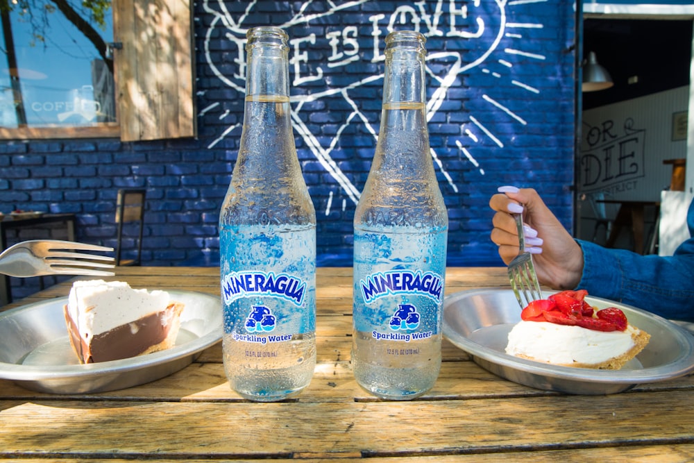 2 blue and white glass bottles on brown wooden table