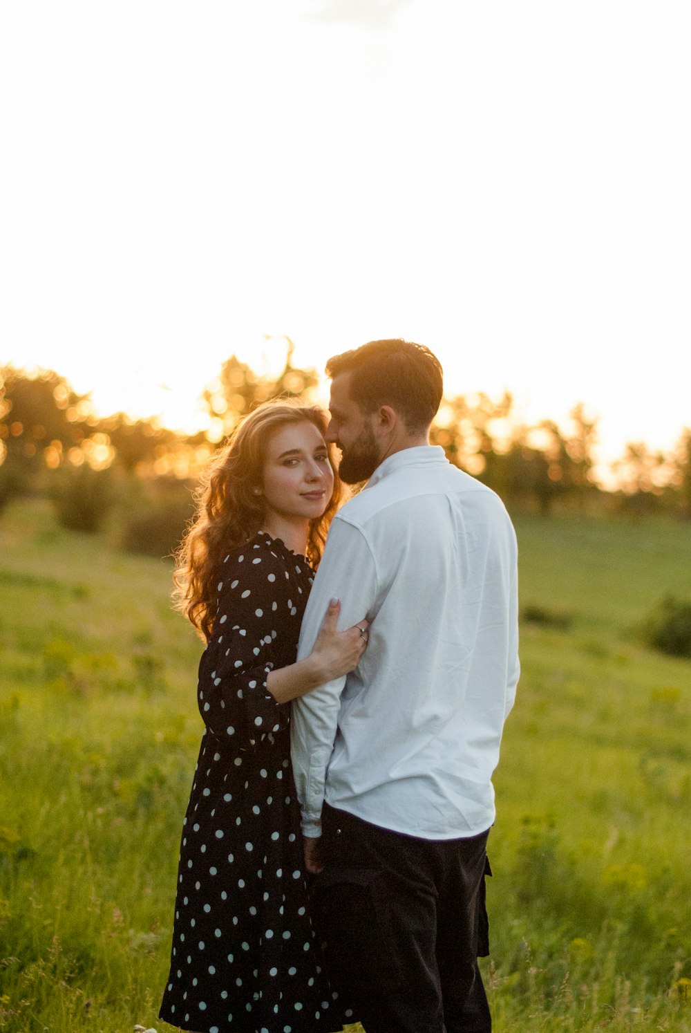 man in white dress shirt and woman in black and white polka dot dress