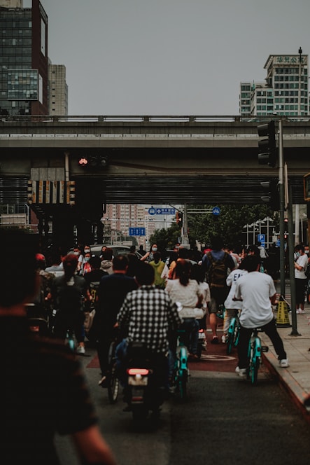 City street bustling with people using various urban mobility solutions like bikes and scooters.