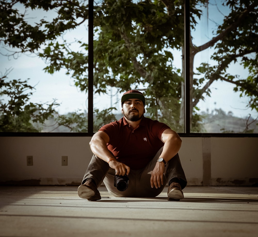 man in black crew neck t-shirt and white pants sitting on floor