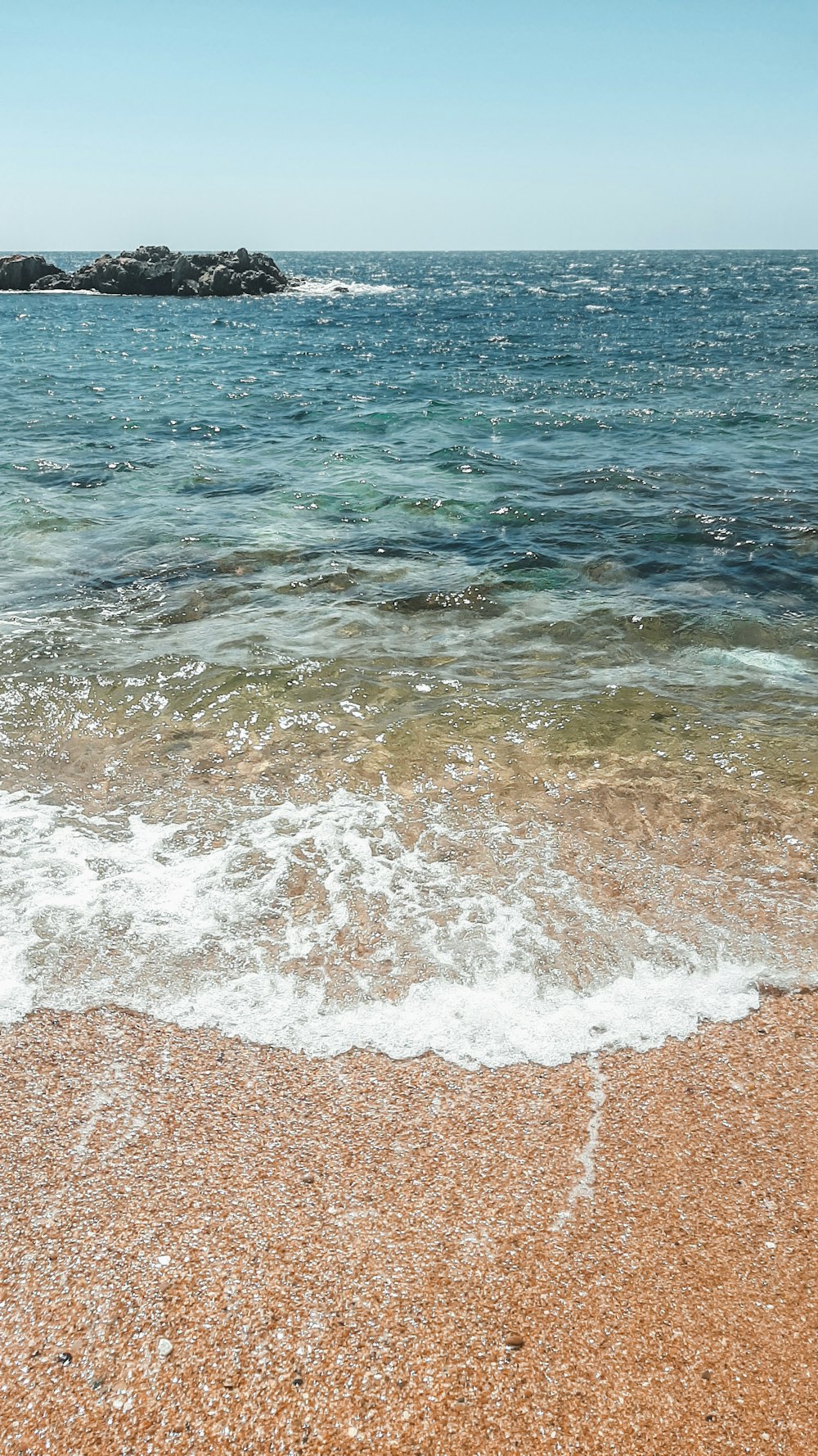 brown sand near body of water during daytime