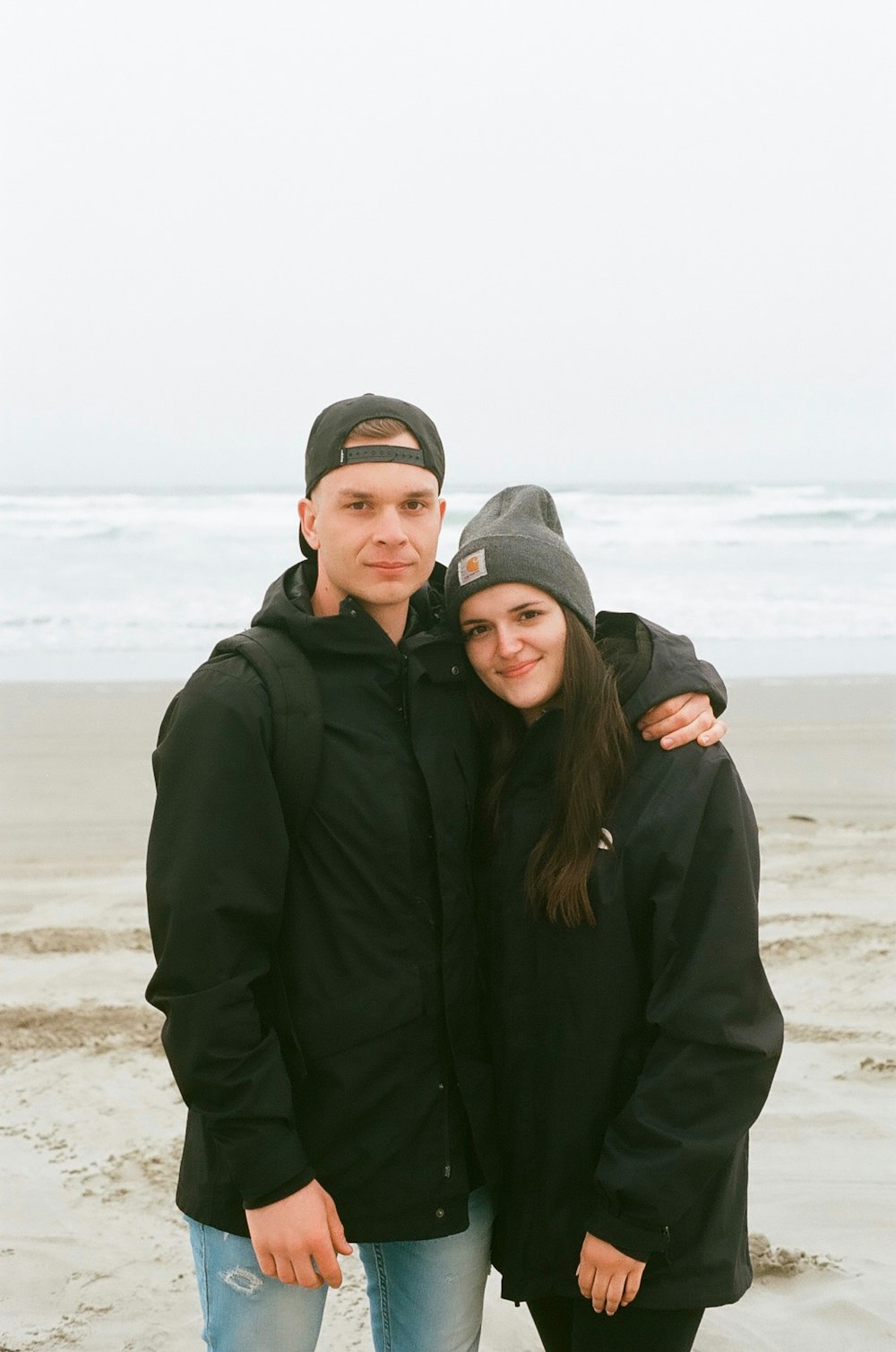 Homme en sweat à capuche noir à côté d’une femme en sweat à capuche noir