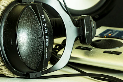 Close-up of headphones resting on a microphone in the studio.