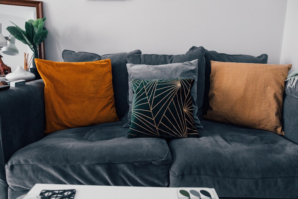 orange throw pillow on black couch