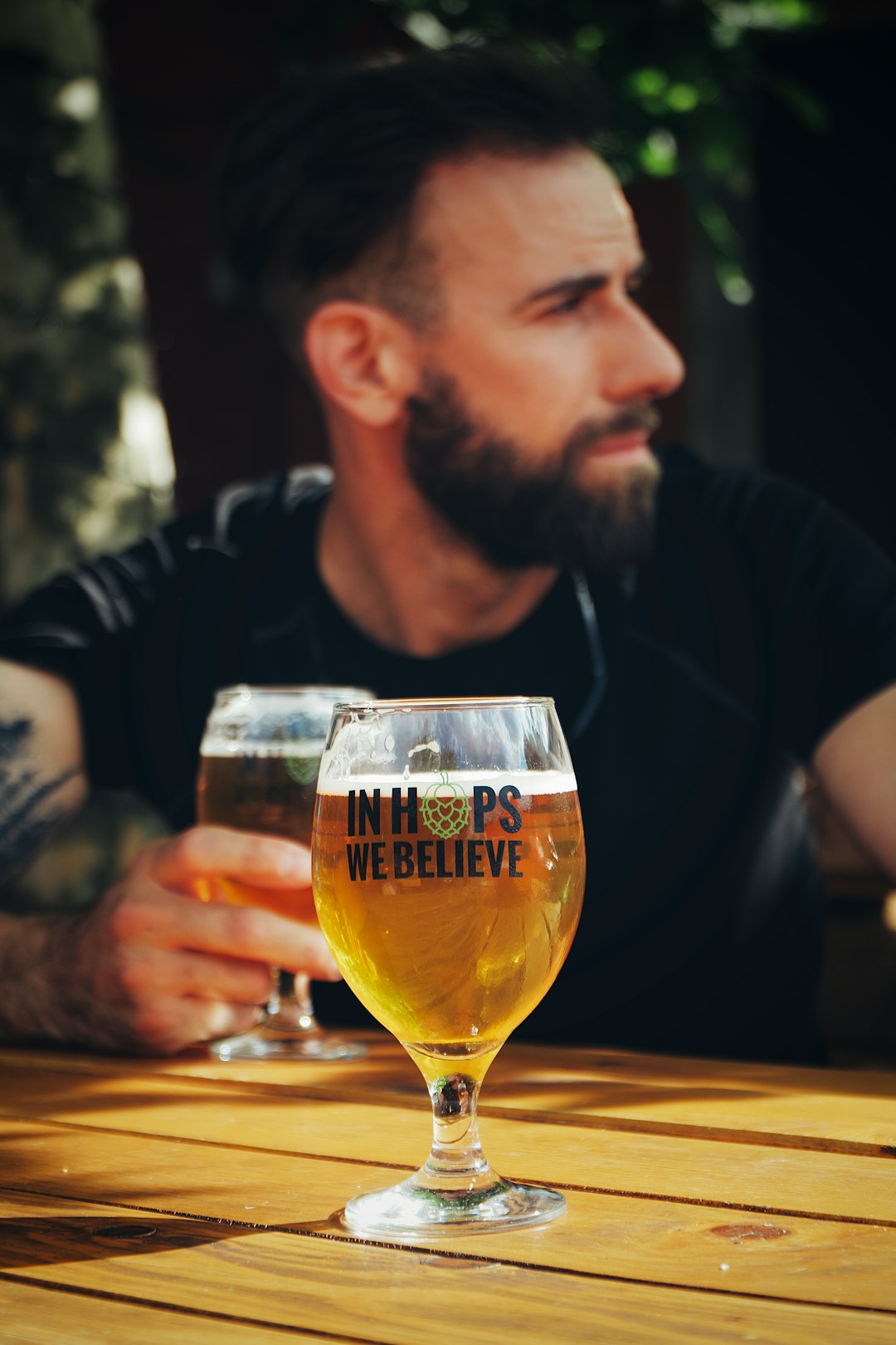  man in black long sleeve shirt holding clear drinking glass cold tap