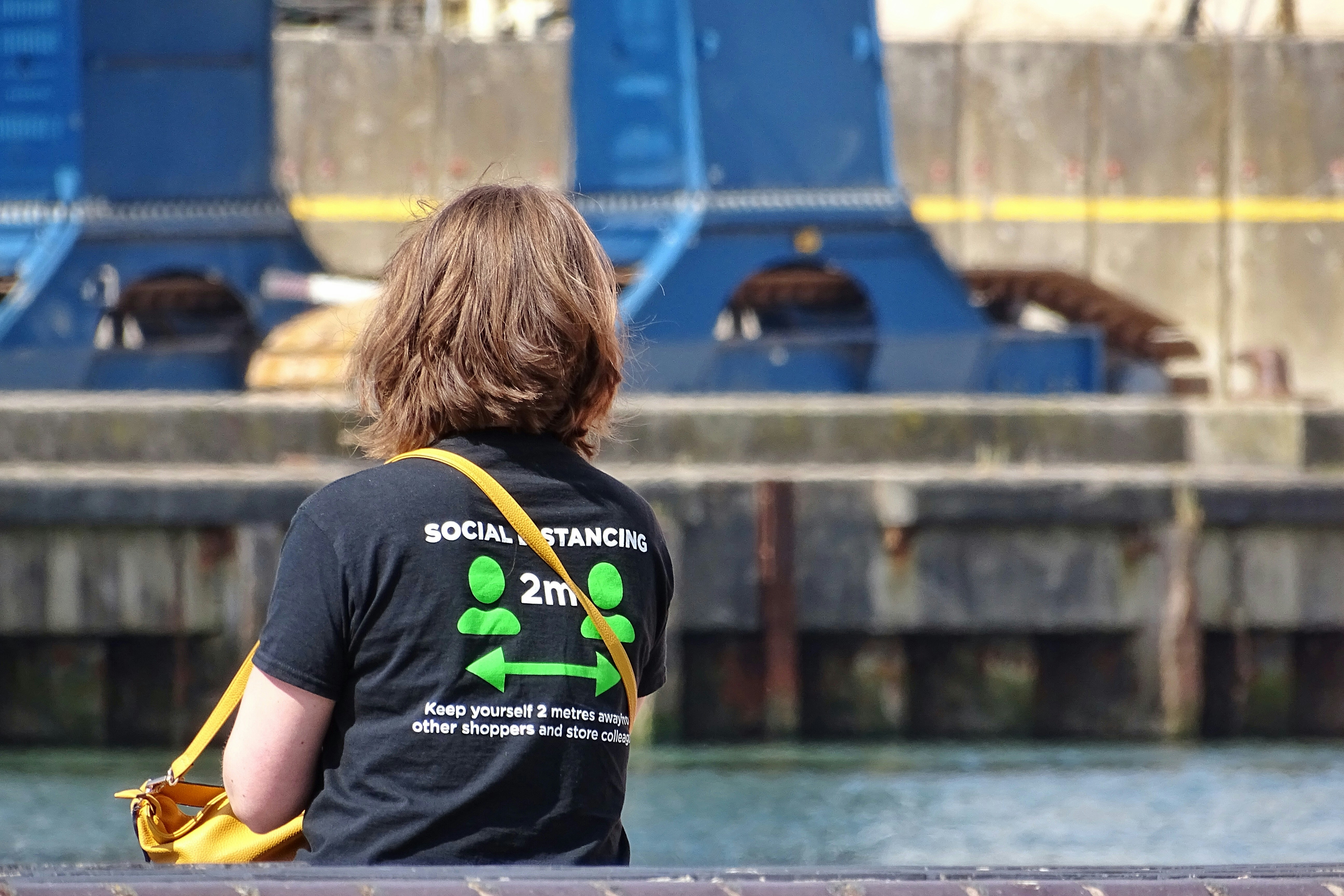 Frau im schwarzen T-Shirt sitzt auf gelbem Stuhl