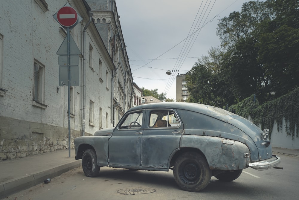 gray sedan parked beside gray concrete building during daytime