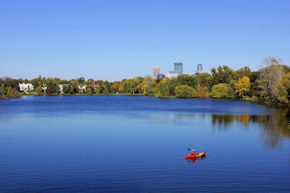 persona in kayak rosso sul lago durante il giorno