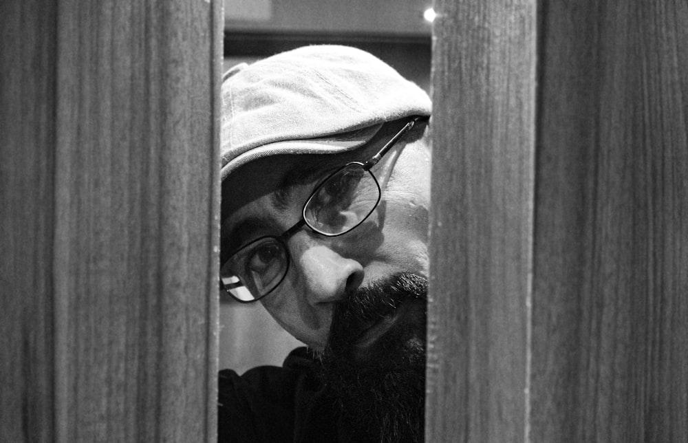 man in black framed eyeglasses and white cap