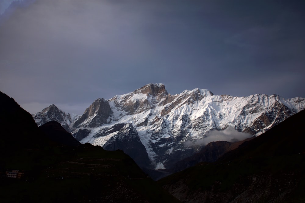 snow covered mountain under cloudy sky during daytime