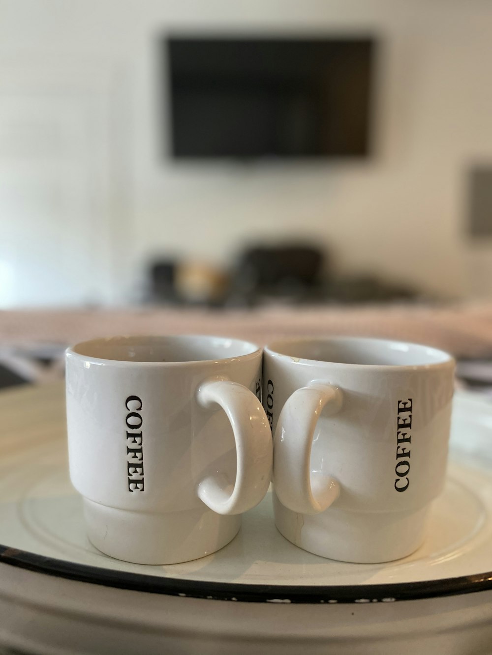 white and black ceramic mug on white ceramic plate