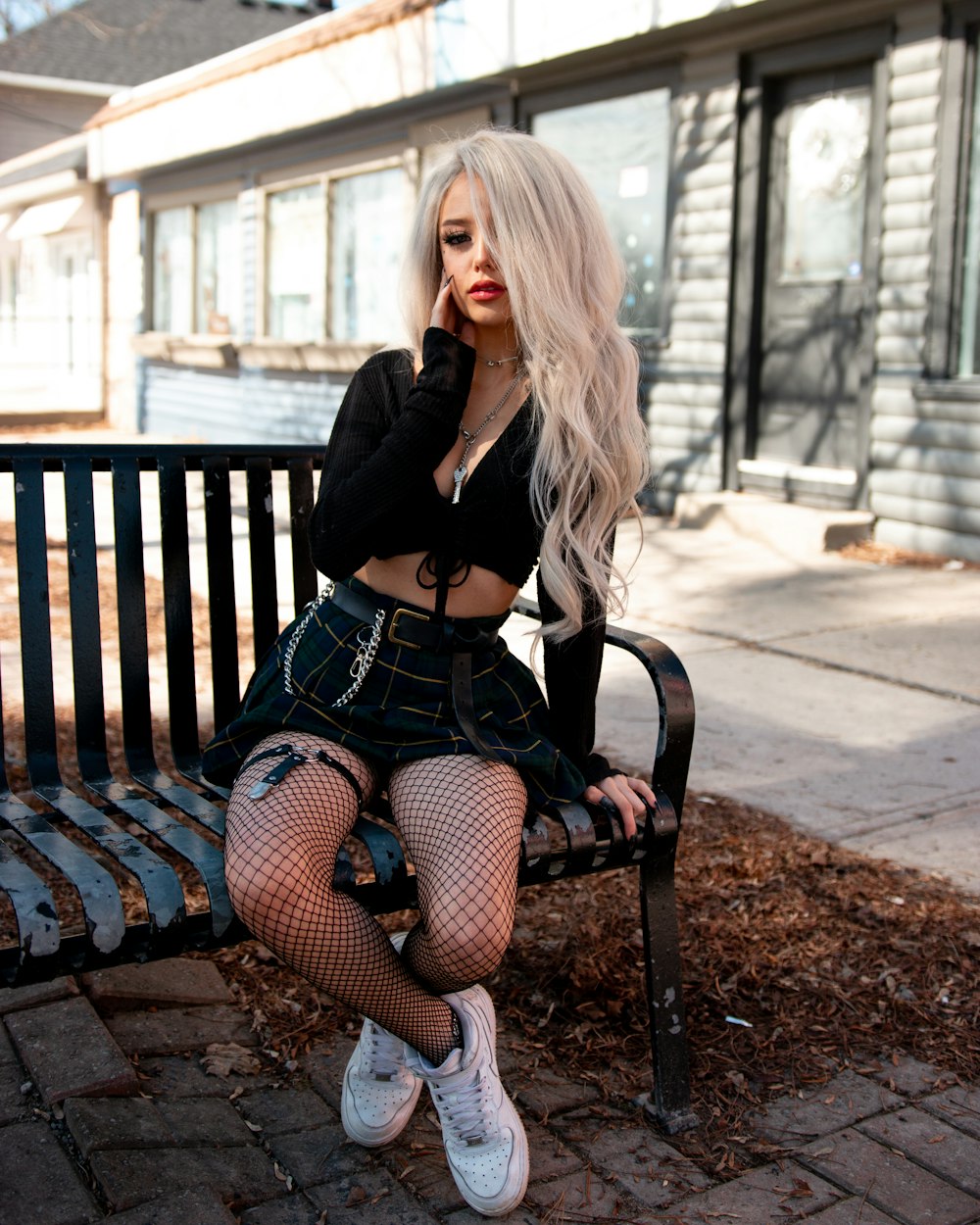 woman in black long sleeve shirt sitting on brown wooden bench