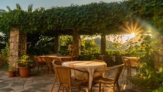 A cozy patio with stone flooring and wooden pergola under natural sunlight.