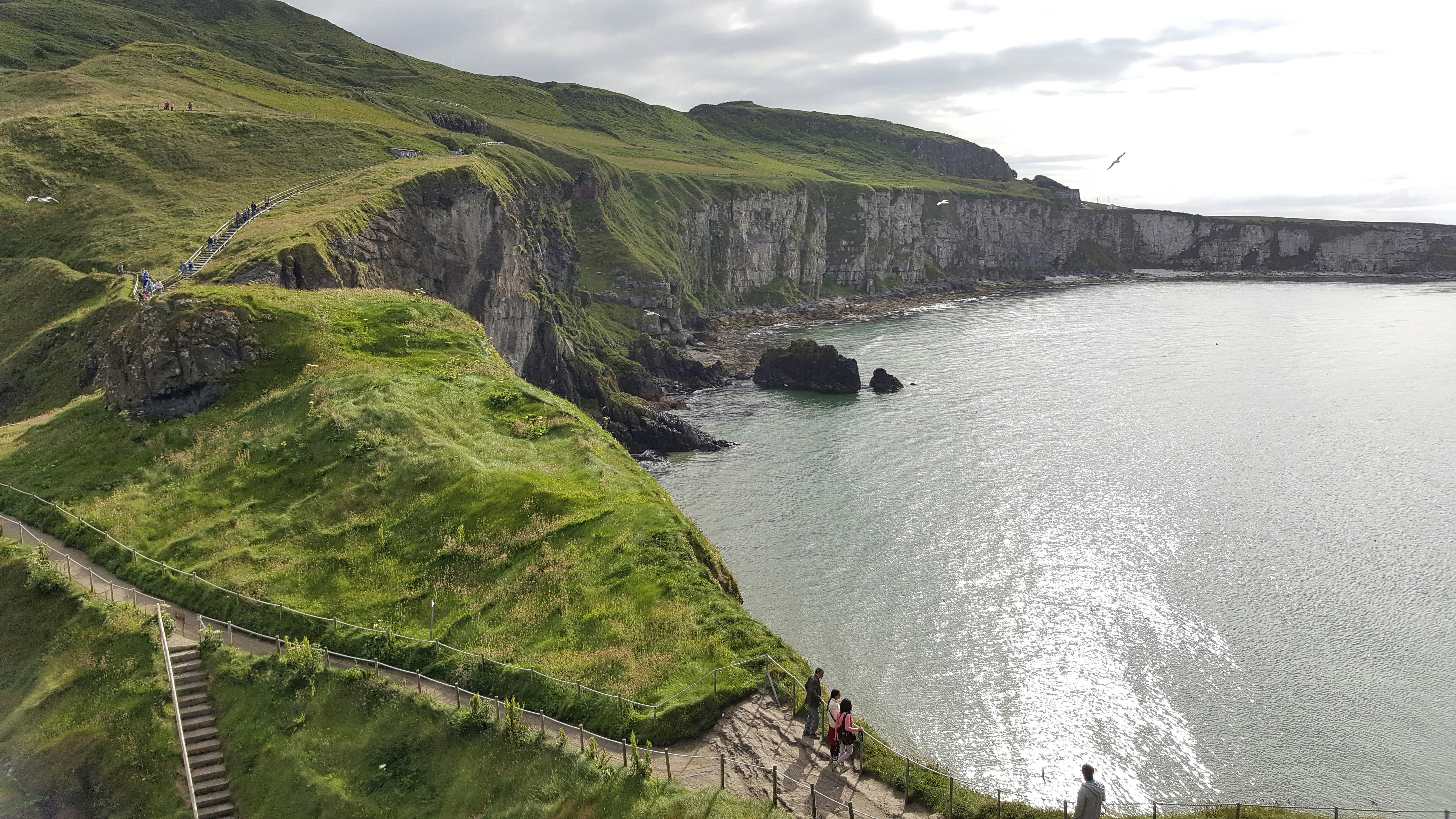 green mountain beside body of water during daytime