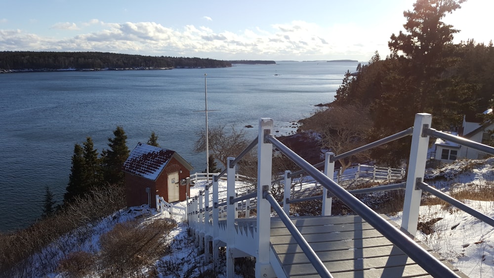 brown and white wooden house near body of water during daytime