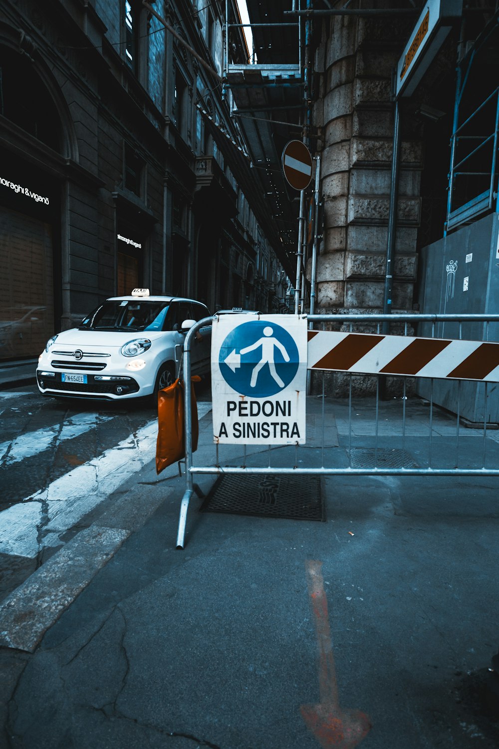 white and orange car parked beside pedestrian lane