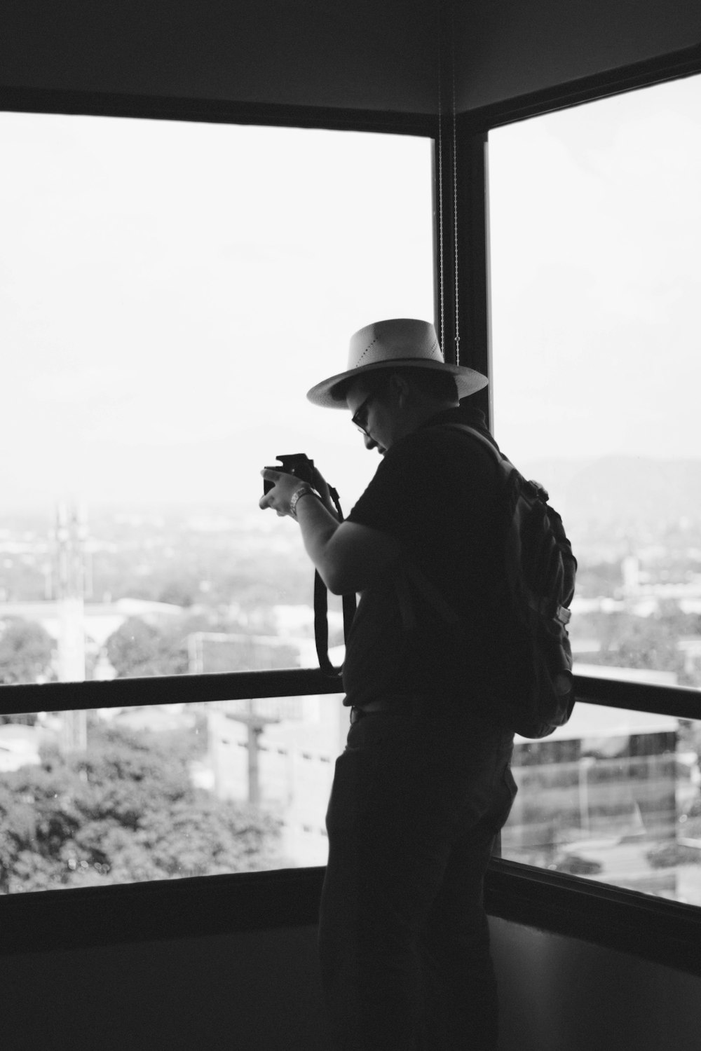 man in black jacket and cap holding camera