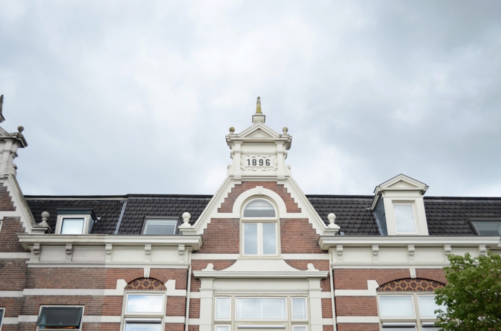 Edificio de hormigón marrón y blanco bajo nubes blancas durante el día