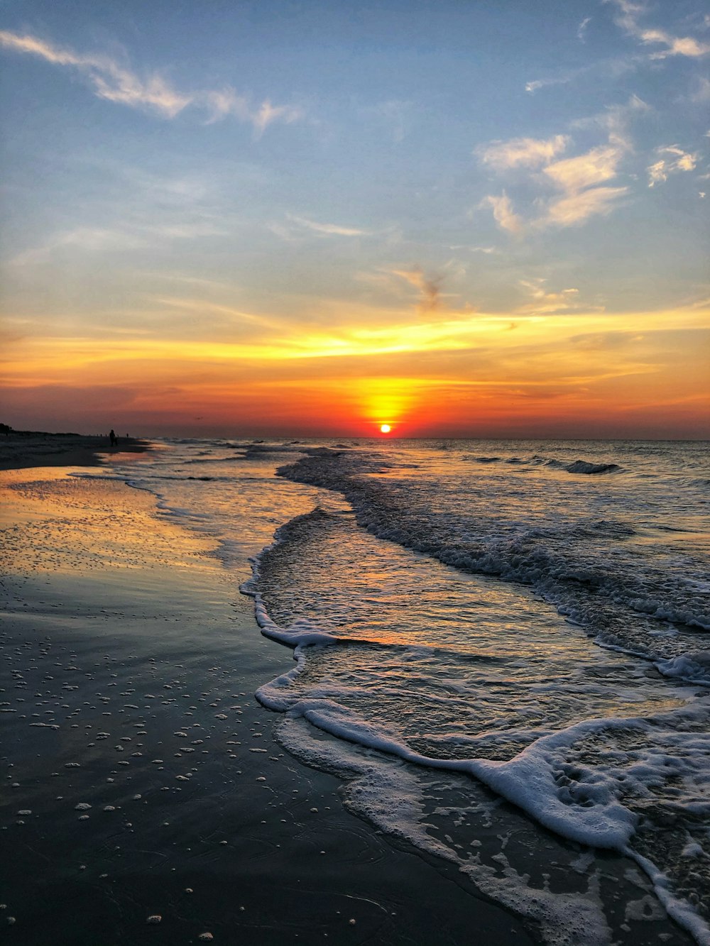 ocean waves crashing on shore during sunset