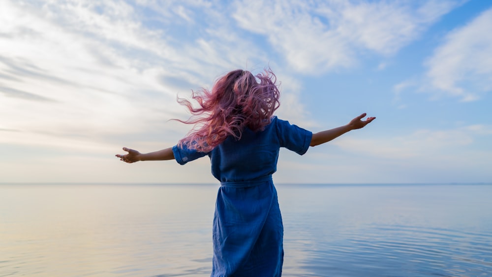 woman in blue shirt standing on water during daytime