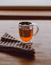clear glass mug containing tea and a metal infuser