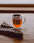 clear glass mug containing tea and a metal infuser