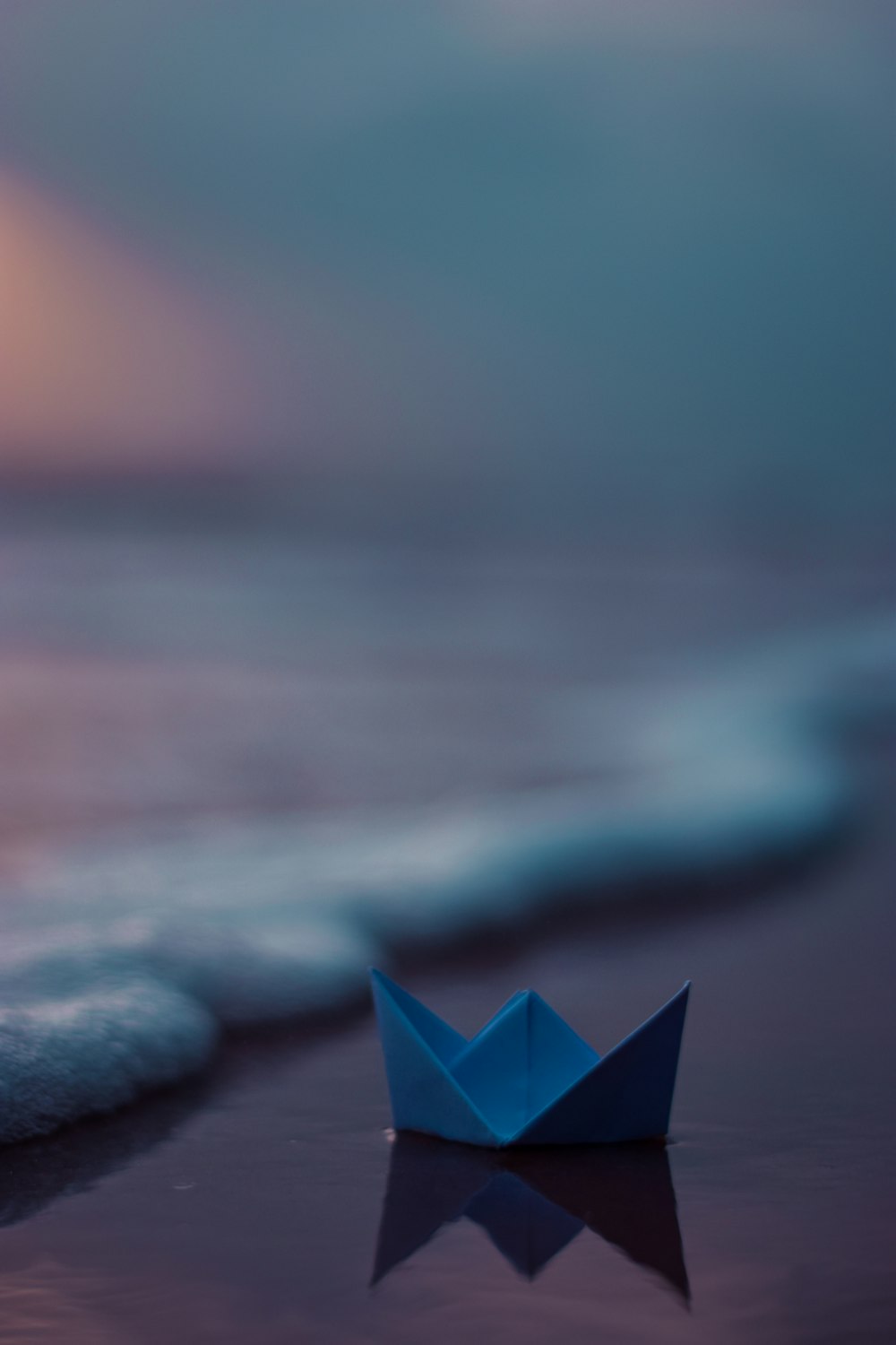 pink paper boat on sea shore during daytime