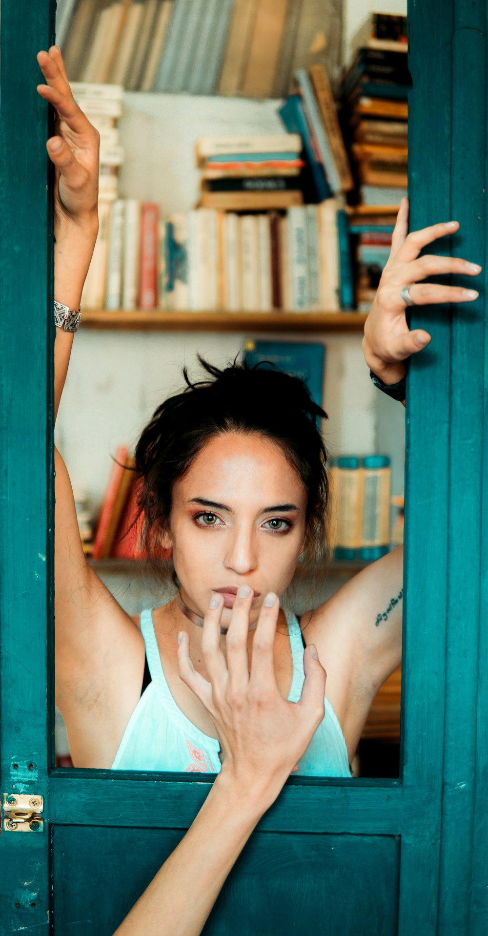 woman in white tank top leaning on white wooden wall