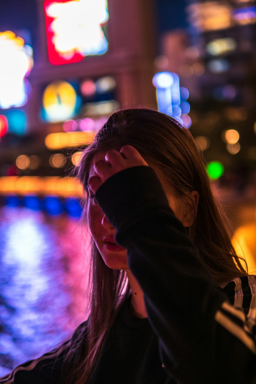 woman in black jacket covering her face with her hair