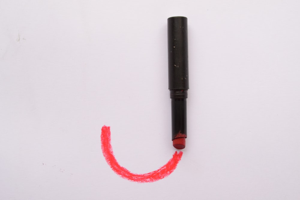 black and red tube on white surface