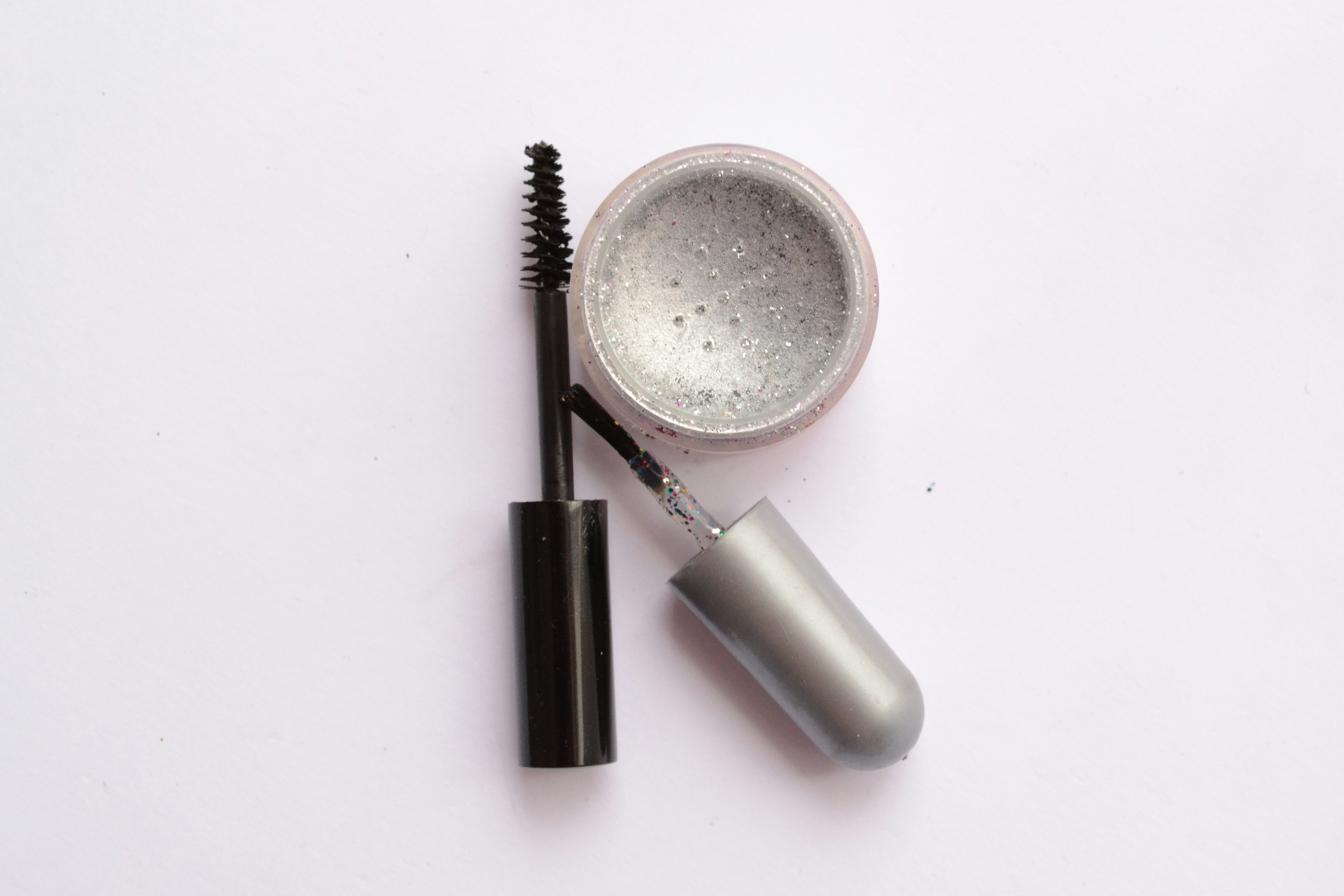 Swiss Beauty volumizing mascara wand with thick bristles on dark moody background