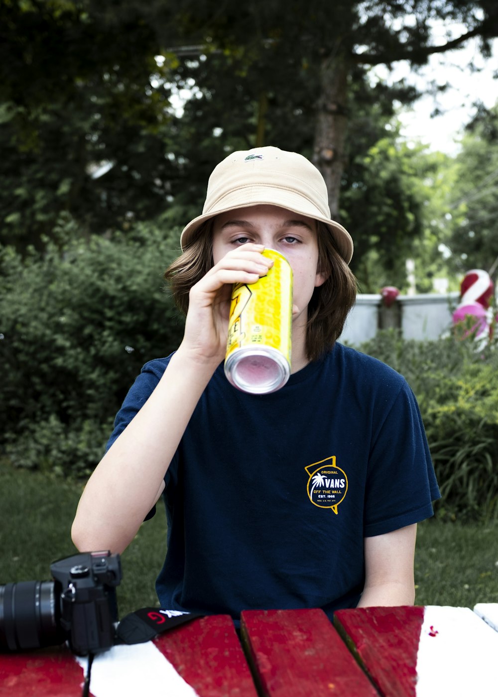 boy in blue crew neck t-shirt holding yellow and white plastic cup