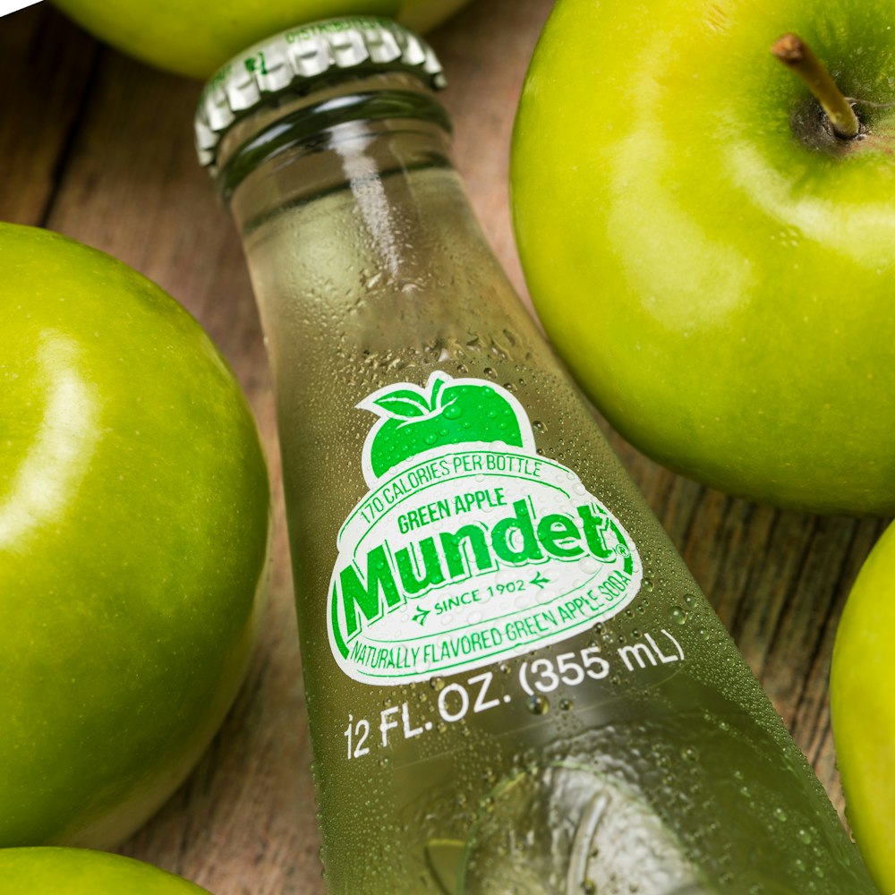 Grüner Apfel neben durchsichtiger Plastikflasche