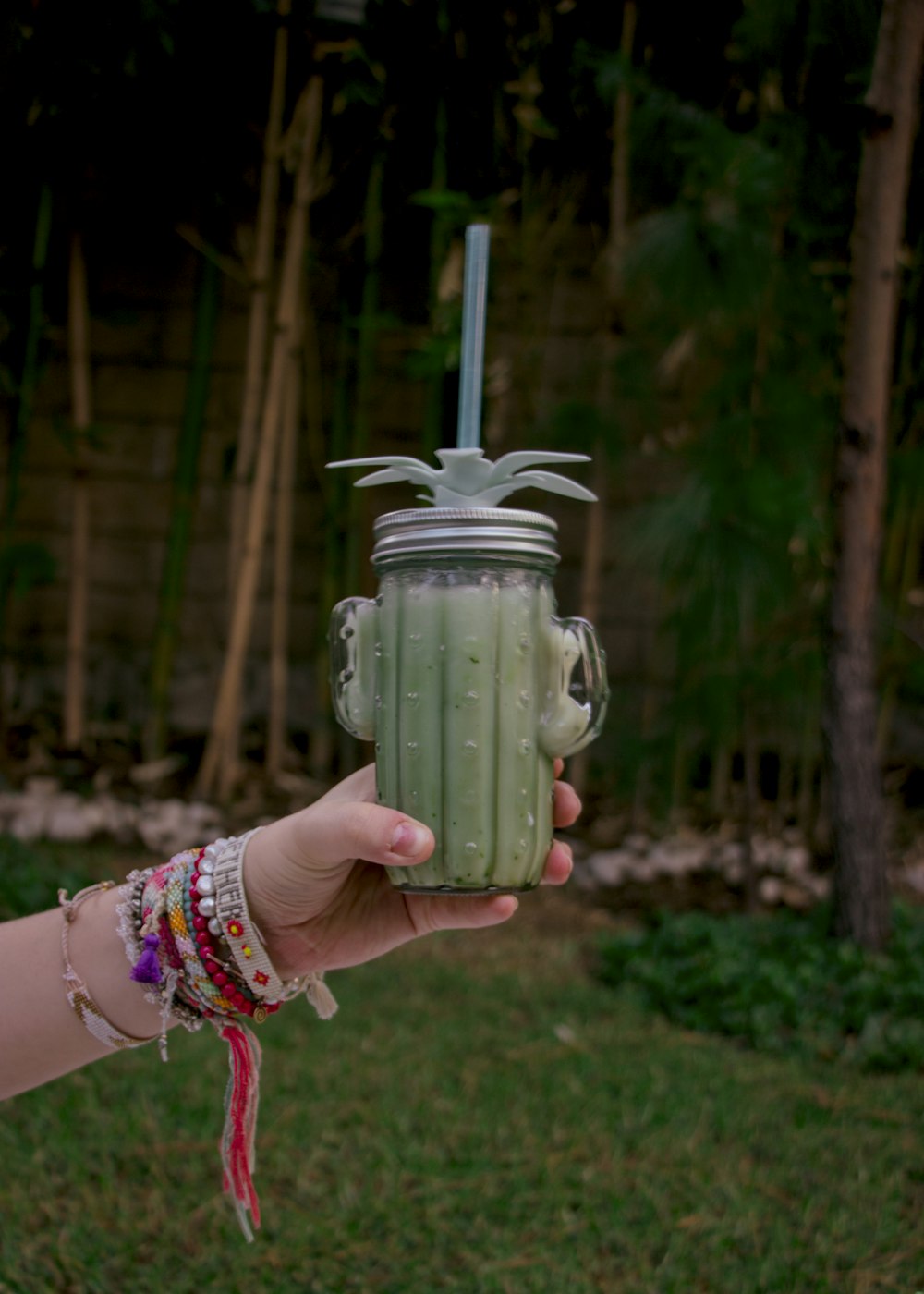 person holding green ceramic jar