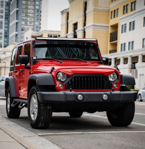 red jeep wrangler on road during daytime