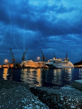 A picturesque harbor at sunset with moored cruise ships and calm waters.