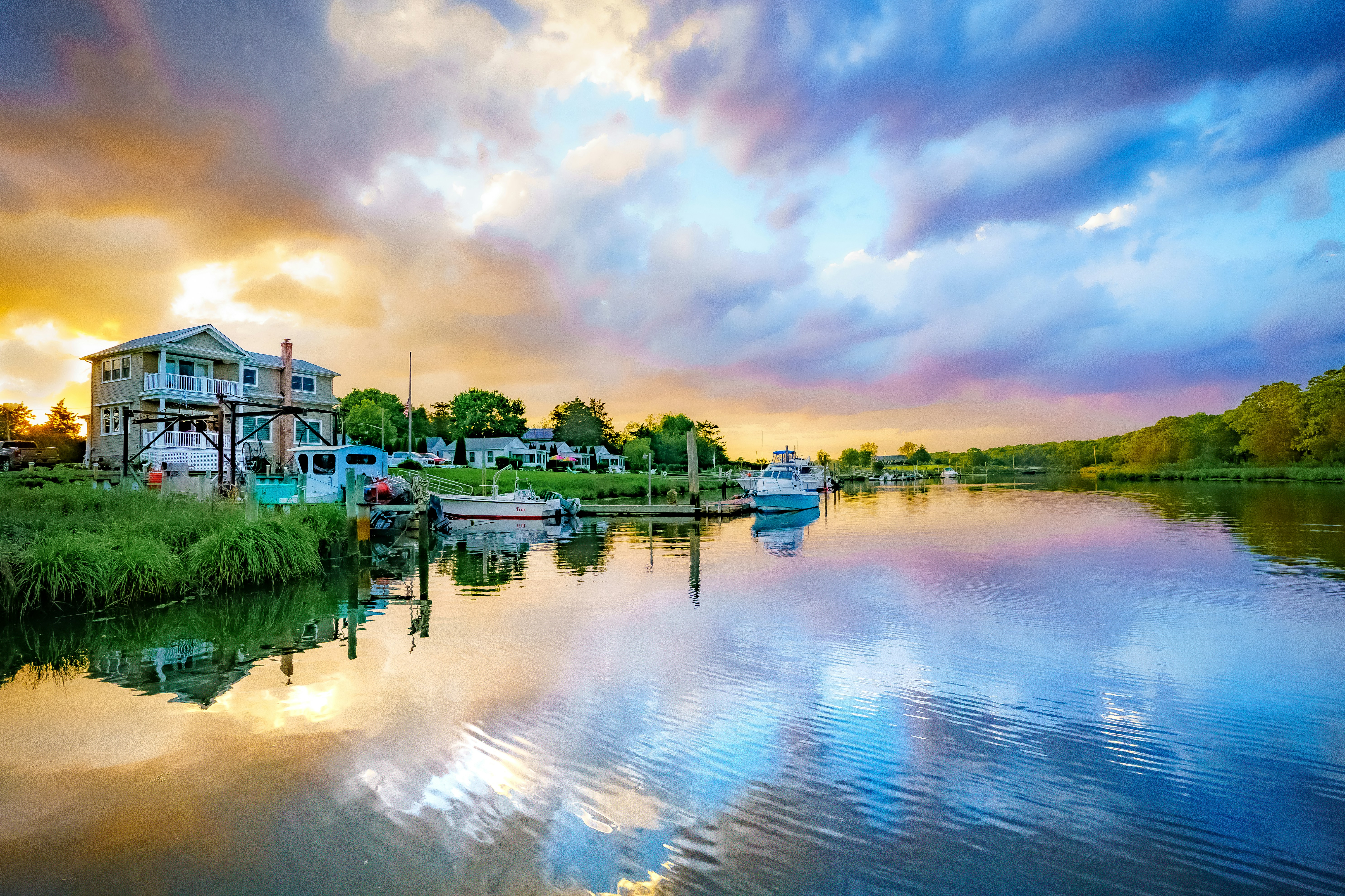 white and brown concrete building near body of water under cloudy sky during daytime