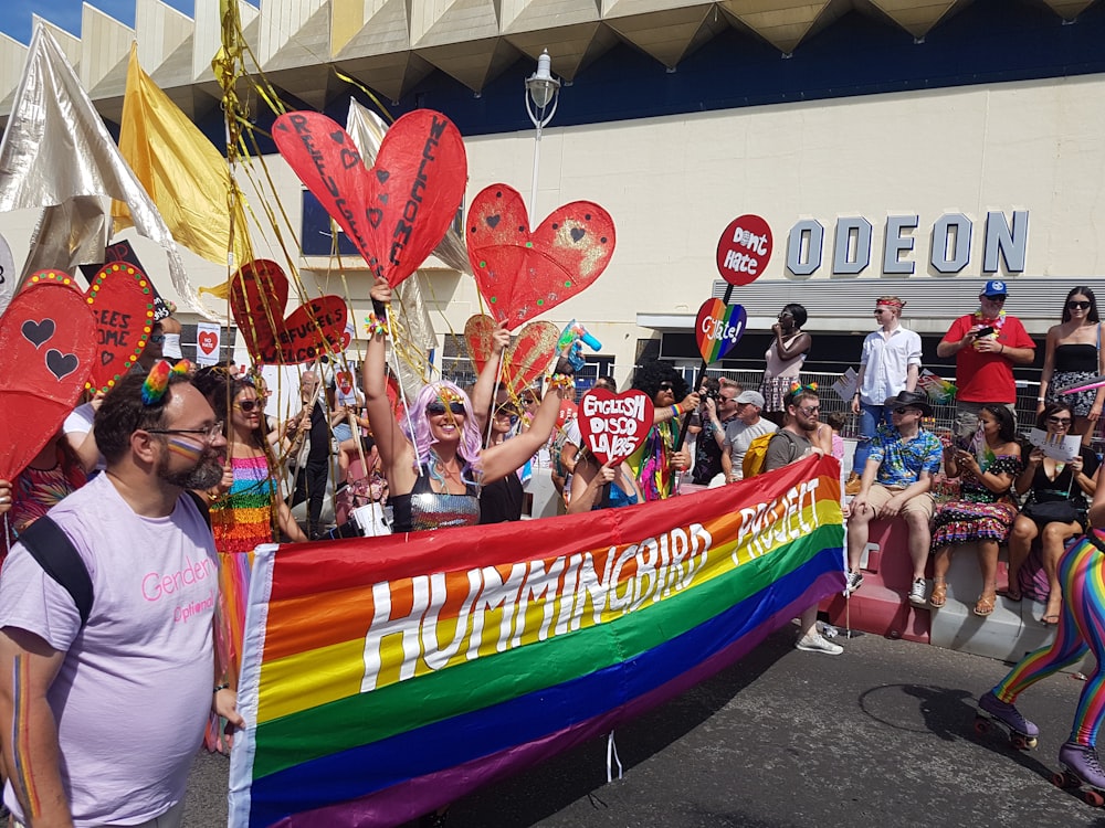 people standing near red blue and yellow banner during daytime