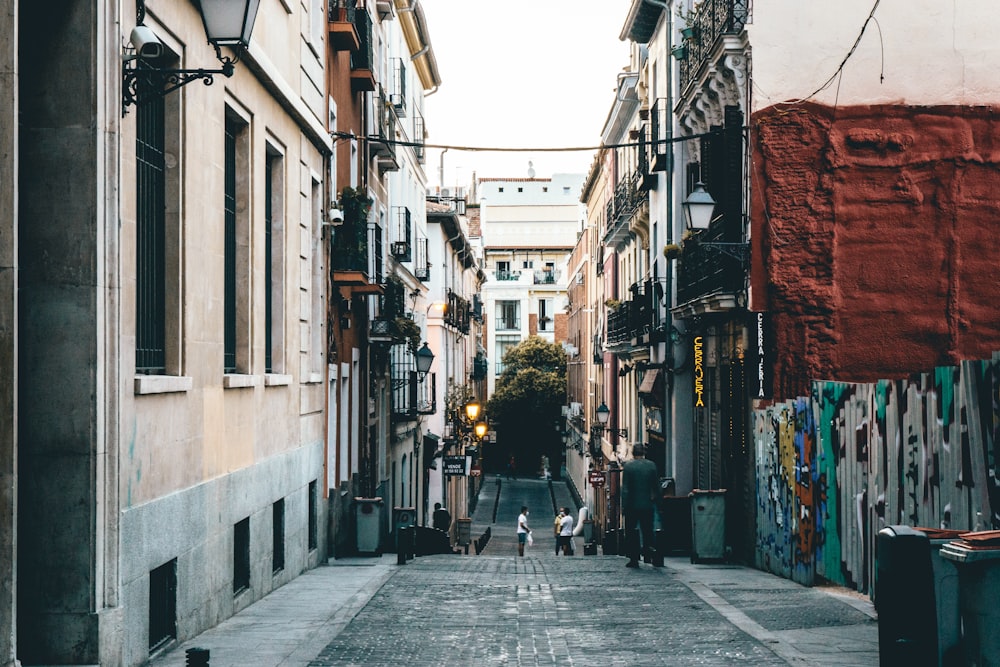 pessoas andando na rua entre os edifícios durante o dia