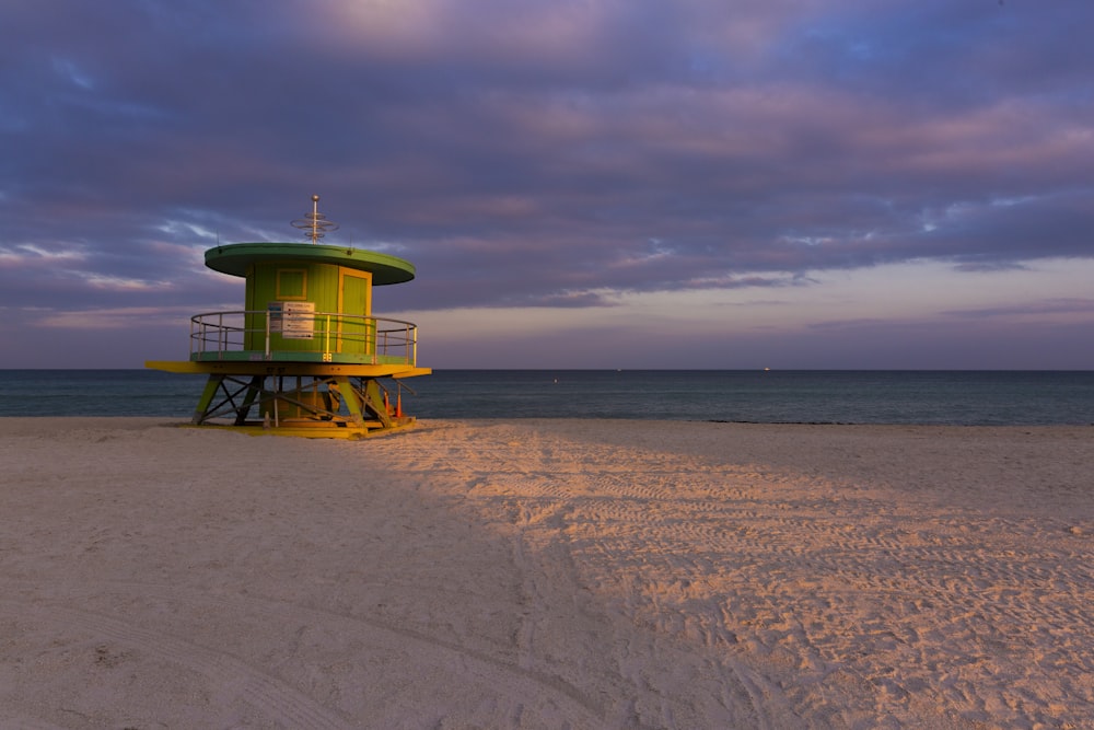 green and white lifeguard tower on beach during daytime