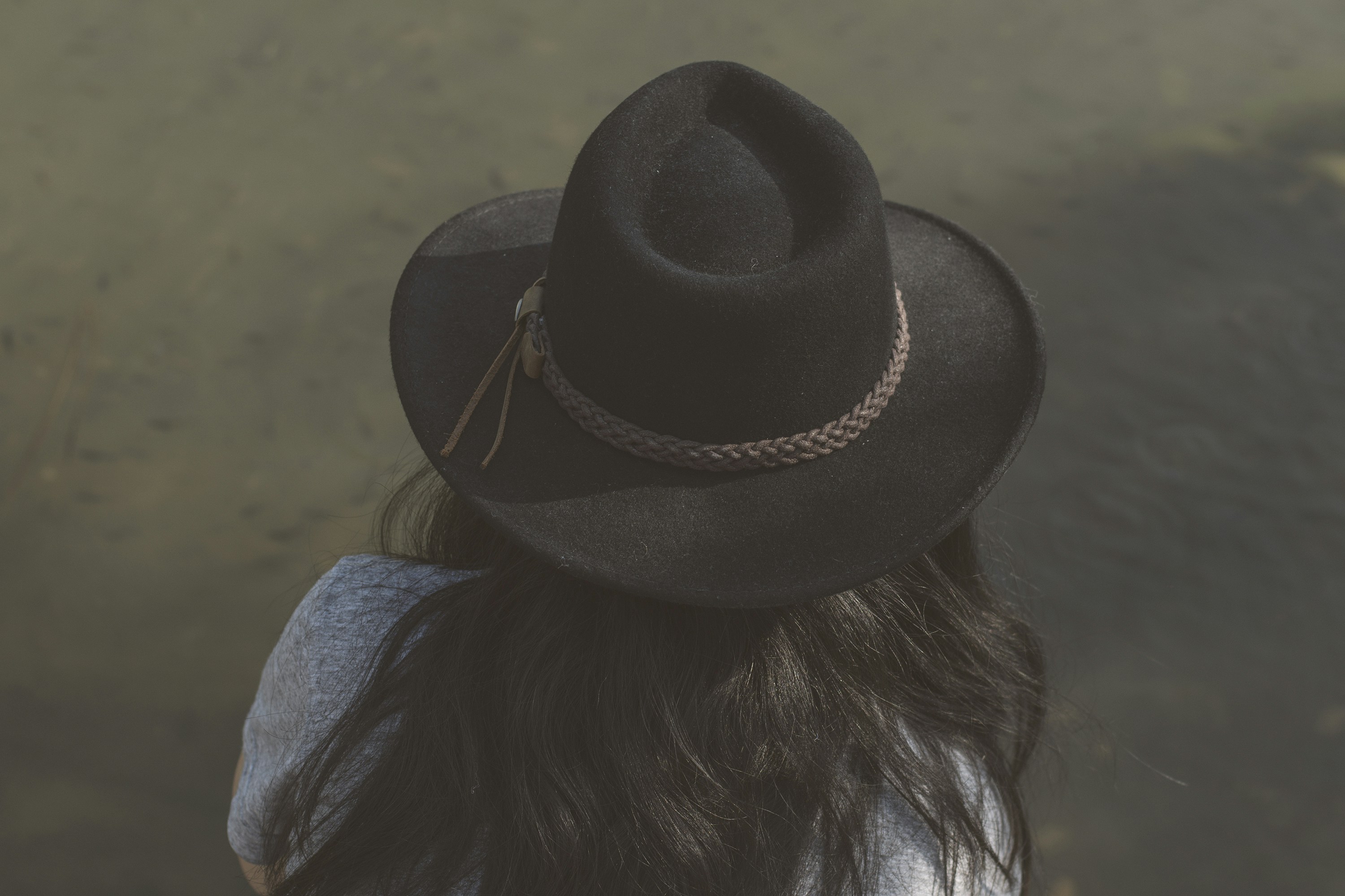 woman in blue denim jacket wearing black fedora hat