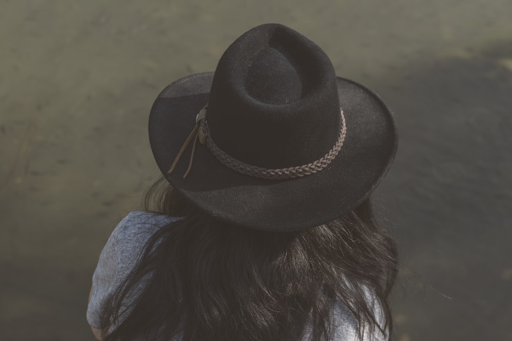 woman in blue denim jacket wearing black fedora hat