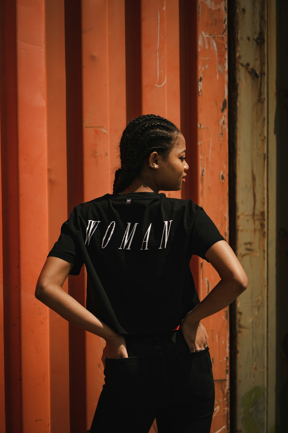 boy in black nike crew neck t-shirt standing beside brown wooden door