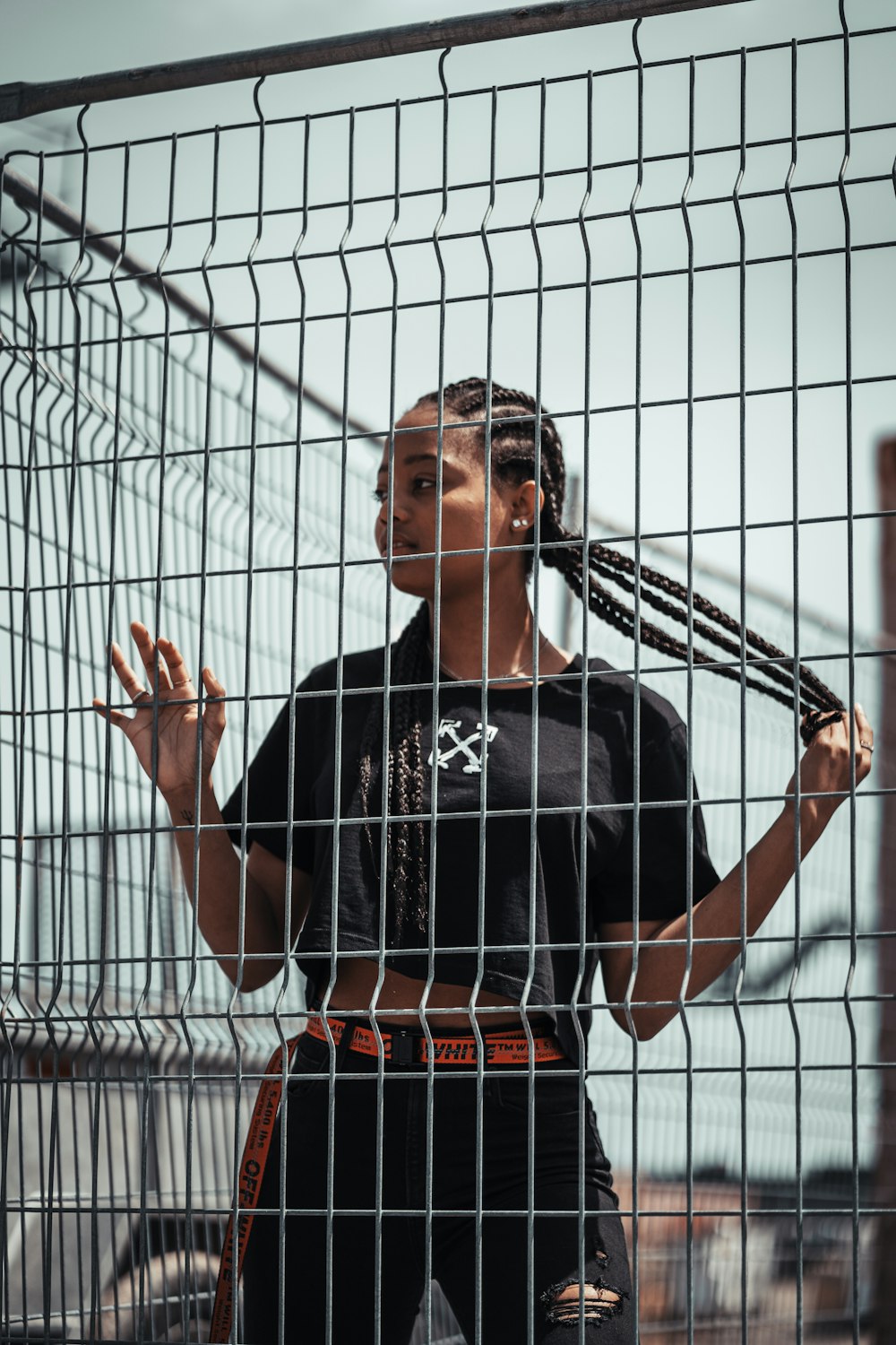 man in black crew neck t-shirt standing beside white metal fence