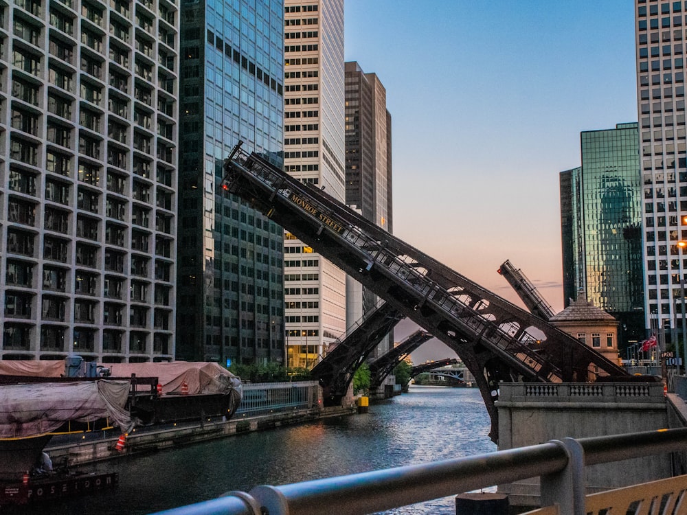 bridge over river near city buildings during daytime